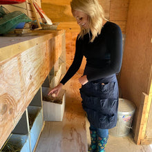 Load image into Gallery viewer, A person wearing an egg collecting apron is gathering eggs in a coop.